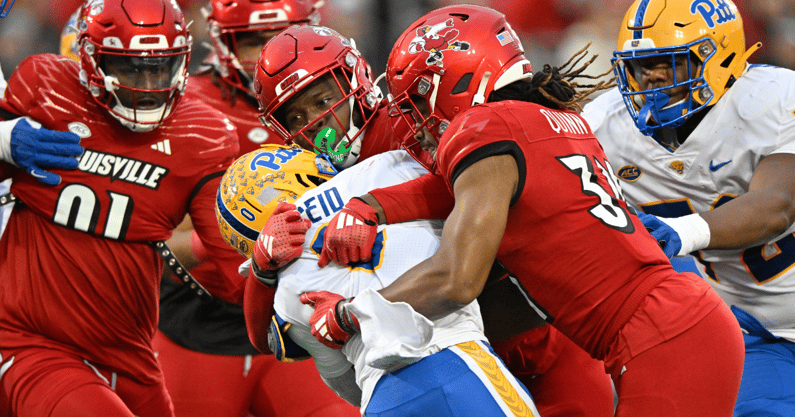 Nov 23, 2024; Louisville, Kentucky, USA; Louisville Cardinals linebacker Stanquan Clark (6) and linebacker TJ Quinn (34) tackle Pittsburgh Panthers running back Desmond Reid (0) during the first half at L&N Federal Credit Union Stadium. Mandatory Credit: Jamie Rhodes-Imagn Images