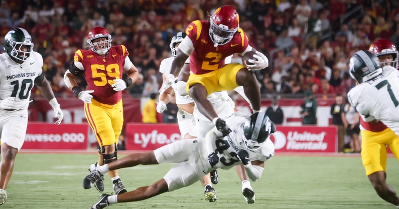 USC running back Waymond Jordan leaps a Michigan State defender