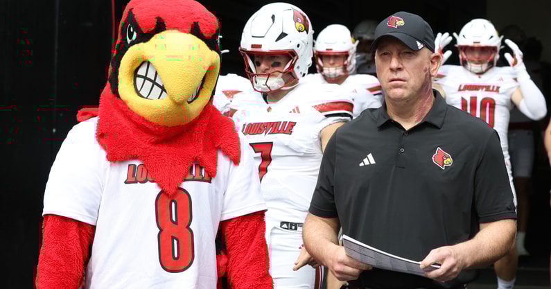 Sep 27, 2025; Pittsburgh, Pennsylvania, USA; Louisville Cardinals head coach Jeff Brohm (right) leads the team onto the field to play the Pittsburgh Panthers at Acrisure Stadium. Mandatory Credit: Charles LeClaire-Imagn Images