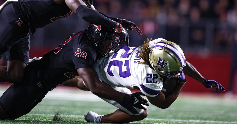 Washington running back Cameron Davis is tackled by Rutgers linebacker Dariel Djabome