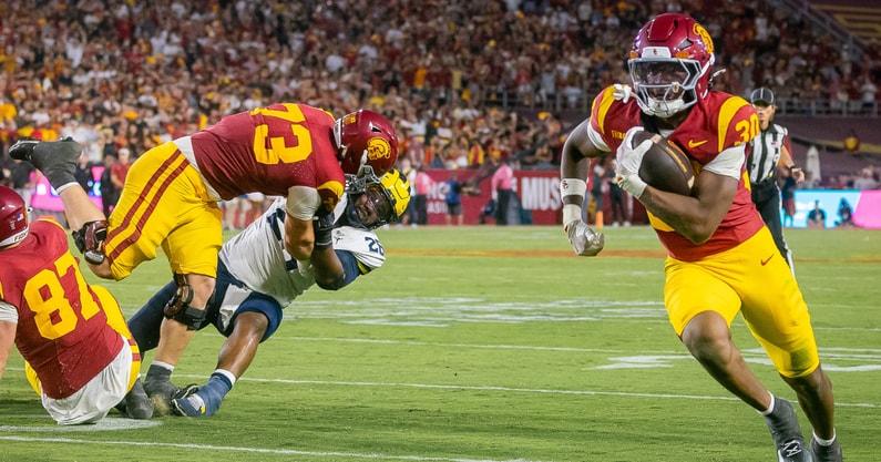 USC lineman Tobias Raymond blocks a Michigan defender as running back King Miller runs for a touchdown