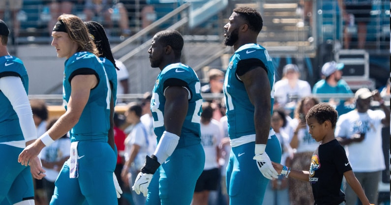 Jacksonville Jaguars Jacksonville Jaguars punter Logan Cooke (9), Jacksonville Jaguars quarterback Trevor Lawrence (16), Jacksonville Jaguars linebacker Foye Oluokun (23) and defensive end Josh Hines-Allen walks with his son Wesley, 8, right, a cancer survivor, in tow as they walk on the field. Wesley was the honorary captain for Sunday’s game against the Seattle Seahawks in an NFL football game at EverBank Stadium, Sunday, Oct. 12, 2025, in Jacksonville, Fla. [Doug Engle/Florida Times-Union]