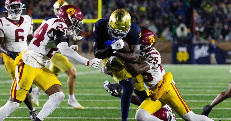 Notre Dame Fighting Irish running back Jeremiyah Love (4) runs the ball while USC Trojans cornerback Marcelles Williams (25) defends in the second half at Notre Dame Stadium