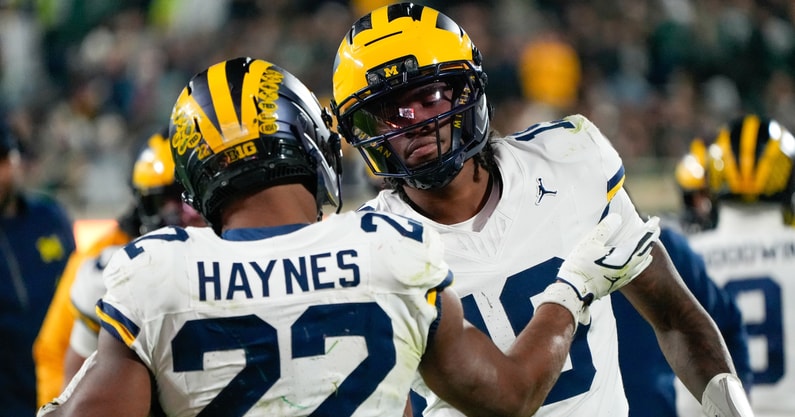 Oct 25, 2025; East Lansing, Michigan, USA; Michigan Wolverines running back Justice Haynes (22) reacts with quarterback Bryce Underwood (19) after scoring a touchdown against the Michigan Wolverines during the second half at Spartan Stadium. Mandatory Credit: Brendan Mullin-Imagn Images
