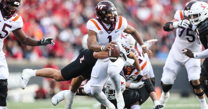 Louisville Cardinals defensive lineman Mason Reiger (95) gets an arm around Virginia Tech Hokies quarterback Kyron Drones (1) as the Cards rolled past Virginia Tech 34-3 Saturday. Nov.4, 2023.