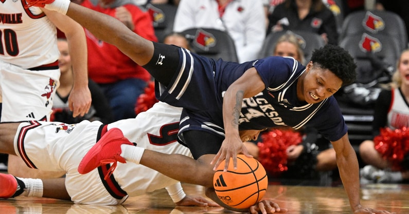 Nov 6, 2025; Louisville, Kentucky, USA; Jackson State Tigers guard Daeshun Ruffin (24) scrambles for the ball with Louisville Cardinals forward Khani Rooths (9) during the second half at KFC Yum! Center. Louisville defeated Jackson State 106-70. Mandatory Credit: Jamie Rhodes-Imagn Images