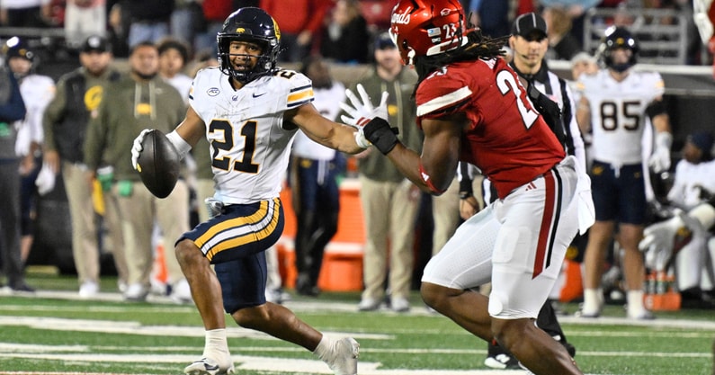 Nov 8, 2025; Louisville, Kentucky, USA; California Golden Bears wide receiver Jacob de Jesus (21) runs the ball against Louisville Cardinals defensive lineman Wesley Bailey (23) in overtime at L&N Federal Credit Union Stadium. California defeated Louisville 29-26. Mandatory Credit: Jamie Rhodes-Imagn Images