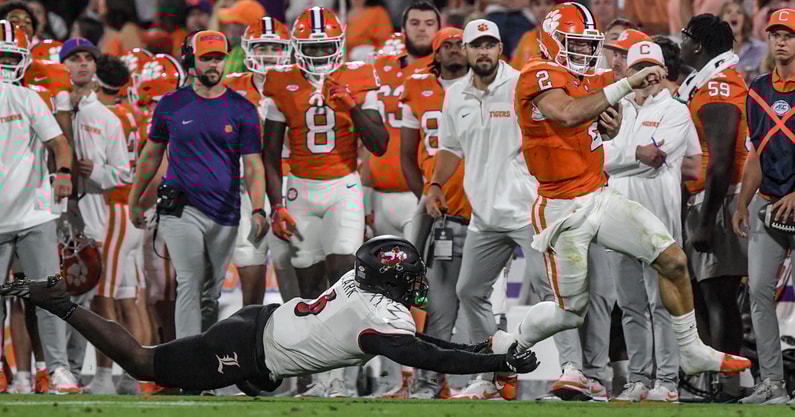 Nov 2, 2024; Clemson, South Carolina, USA; Clemson Tigers quarterback Cade Klubnik (2) runs against Louisville Cardinals linebacker Stanquan Clark (6) during the second quarter at Memorial Stadium. Mandatory Credit: Ken Ruinard-Imagn Images