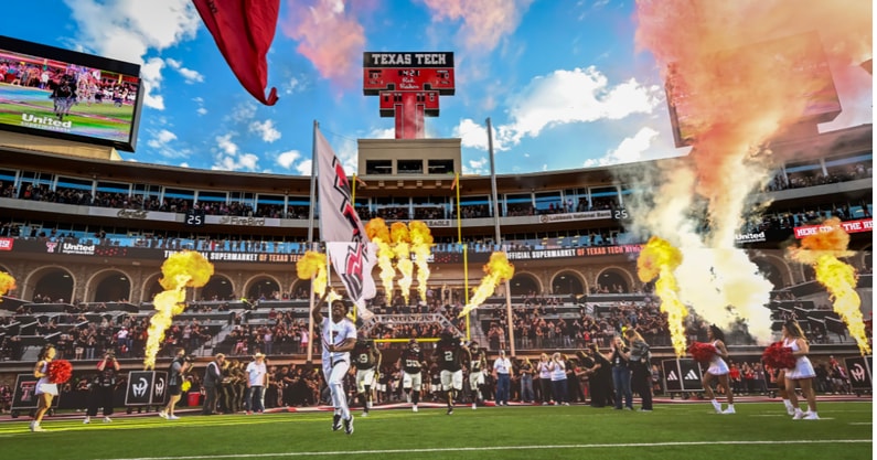 The Texas Tech Red Raiders run out of the tunnel in a packed Jones stadium during homecoming