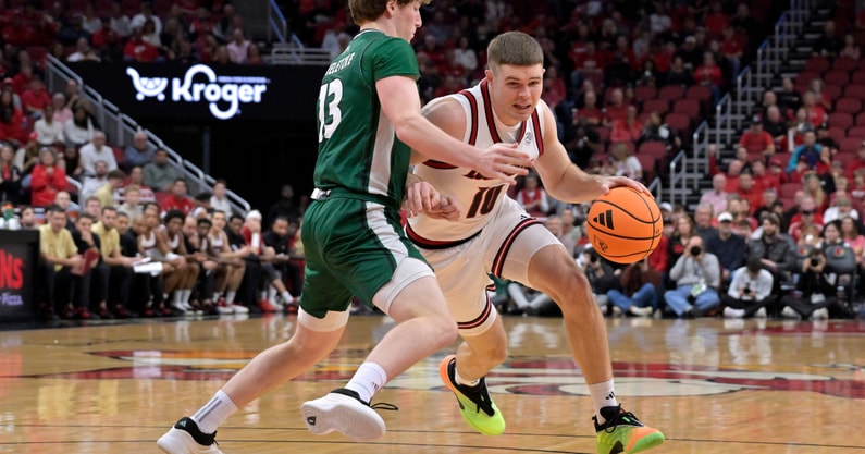 Nov 15, 2025; Louisville, Kentucky, USA; Louisville Cardinals guard Isaac McKneely (10) dribbles against Ohio Bobcats guard Jackson Paveletzke (13) during the first half at KFC Yum! Center. Mandatory Credit: Jamie Rhodes-Imagn Images