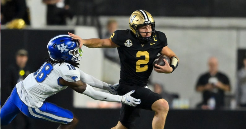 Nov 22, 2025; Nashville, Tennessee, USA; Vanderbilt Commodores quarterback Diego Pavia (2) stiff arms Kentucky Wildcats defensive back Cam Dooley (18) during the second half at FirstBank Stadium. Mandatory Credit: Steve Roberts-Imagn Images