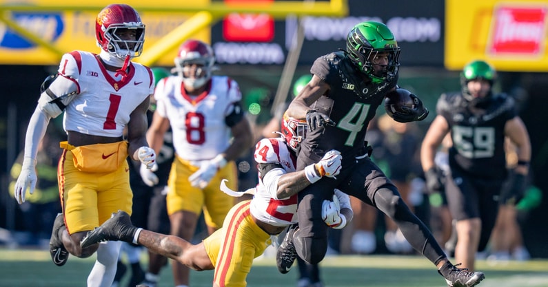 Oregon wide receiver Malik Benson carries the ball amid a tackle from USC safety Christian Pierce as the Oregon Ducks host the USC Trojans on Nov. 22, 2025, at Autzen Stadium in Eugene, Oregon
