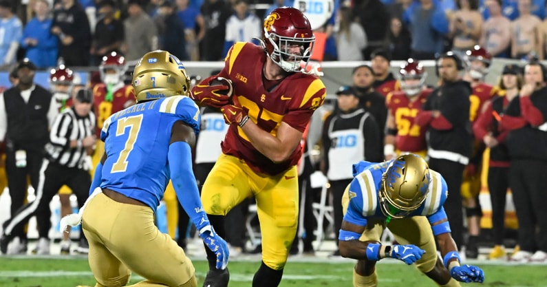 USC Trojans tight end Lake McRee (87) runs a pass between UCLA Bruins defensive back K.J. Wallace (7) and defensive back Bryan Addison (4) during the second quarter at Rose Bowl