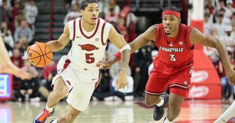 Dec 3, 2025; Fayetteville, Arkansas, USA; Arkansas Razorbacks guard Darius Acuff Jr (5) drives against Louisville Cardinals guard Ryan Conwell (3) during the first half at Bud Walton Arena. Mandatory Credit: Nelson Chenault-Imagn Images