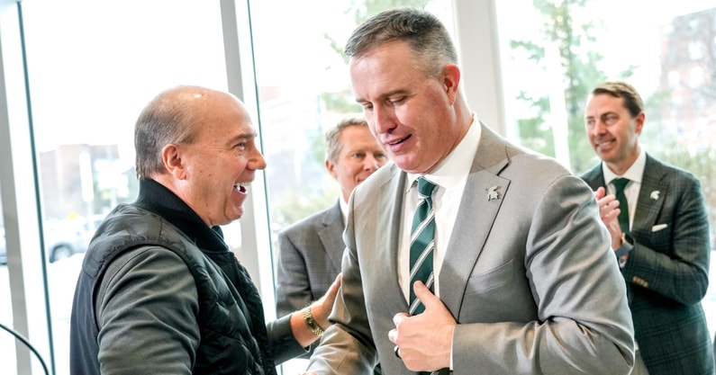 Greg Williams, left, shakes hands with Michigan State's new football coach Pat Fitzgerald during the coach's introductory press conference on Tuesday, Dec. 2, 2025, at the Tom Izzo Football Building. - Nick King, USA TODAY Sports