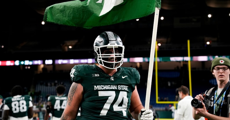 Michigan State offensive lineman Gavin Broscious (74) carries a Michigan State flag after defeating Maryland at Ford Field. - Brendan Mullin, USA TODAY Sports