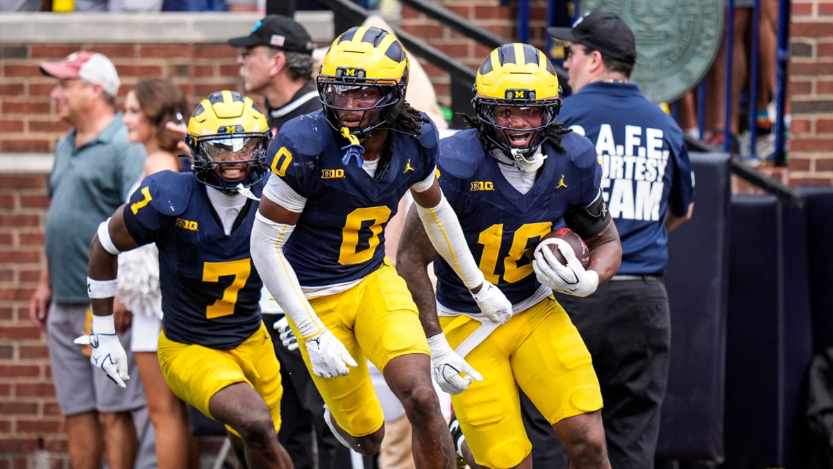 Michigan Wolverines football defenders Chris Bracy, Jyaire Hill and Troy Bowles celebrate a turnover against Oklahoma. (Photo by USA TODAY Network via Reuters Connect)