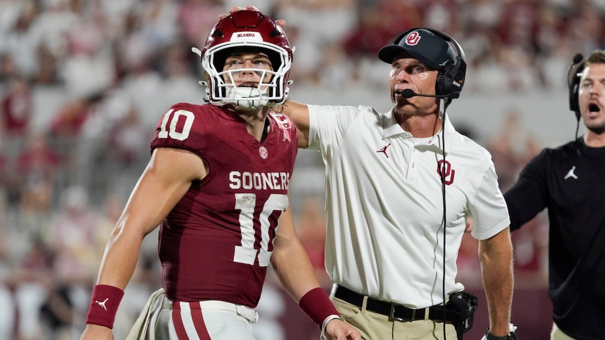 Oklahoma Sooners quarterback John Mateer (10) and coach Brent Venables talk after a play during a college football game between