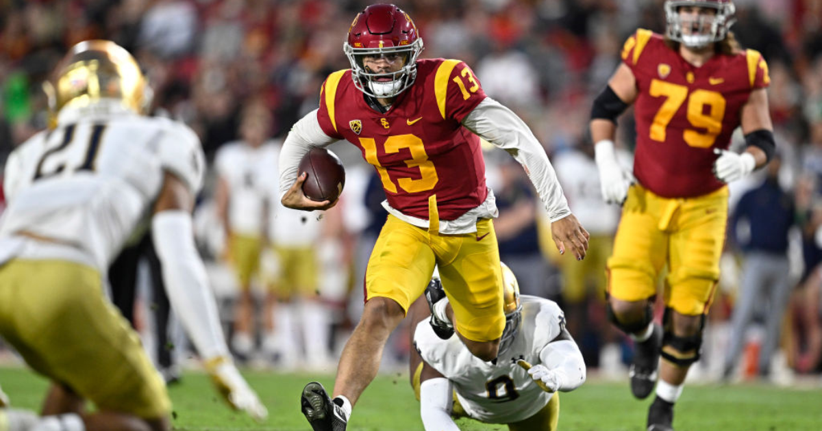 Quarterback Caleb Williams #13 of the USC Trojans scrambles for a first down against defensive lineman Justin Ademilola #9 of the Notre Dame Fighting Irish in the first half of a NCAA football game at the Los Angeles Memorial Coliseum in Los Angeles on Sa