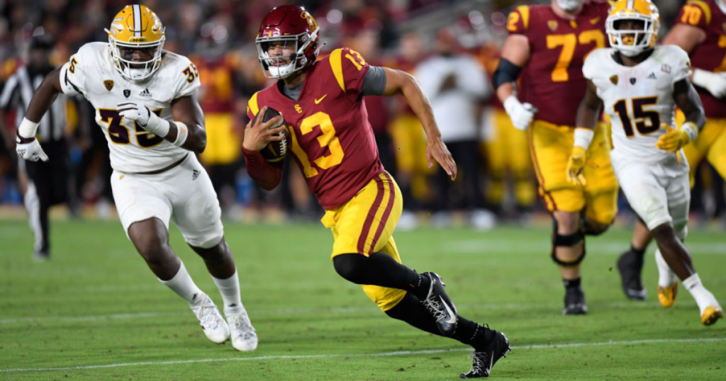 Quarterback Caleb Williams #13 of the USC Trojans rushes out of the pocket and gains a first down ahead of B.J. Green II #35 of the Arizona State Sun Devils