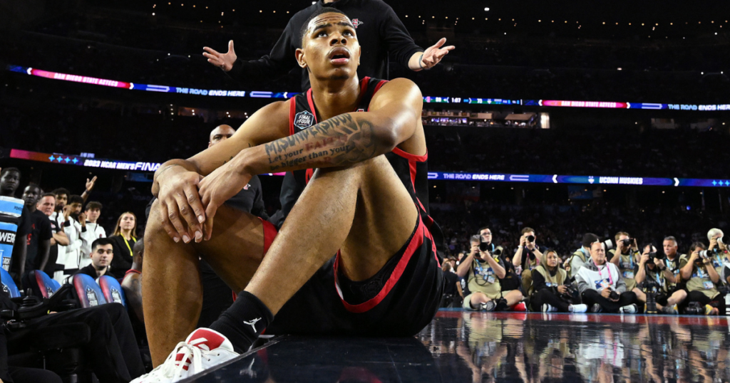 Keshad Johnson #0 of the San Diego State Aztecs watches the game from the bench during the second half of the NCAA Men's Basketball Tournament National Championship game