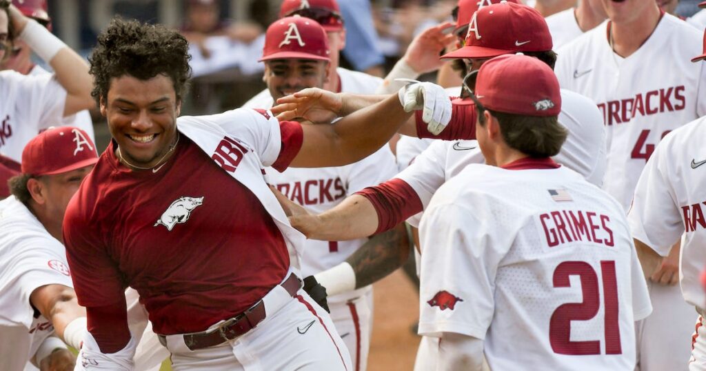 Arkansas batter Kendall Diggs celebrates with teammates after hitting the walk-off solo homer.