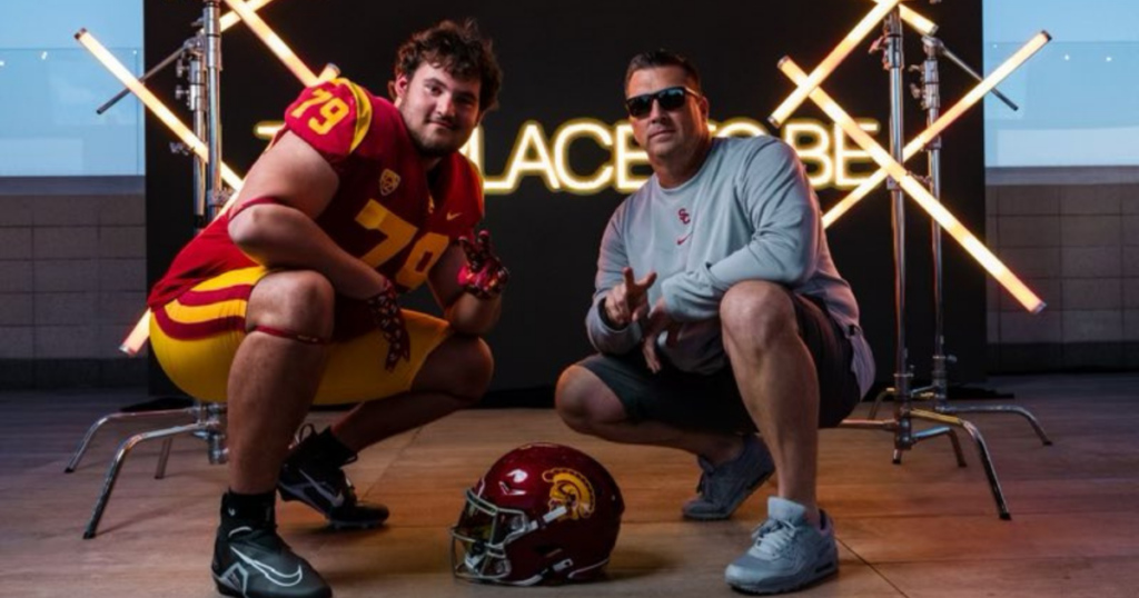 Offensive lineman Hayden Treter in USC uniform poses with offensive line coach Josh Henson during Treter's official visit to USC