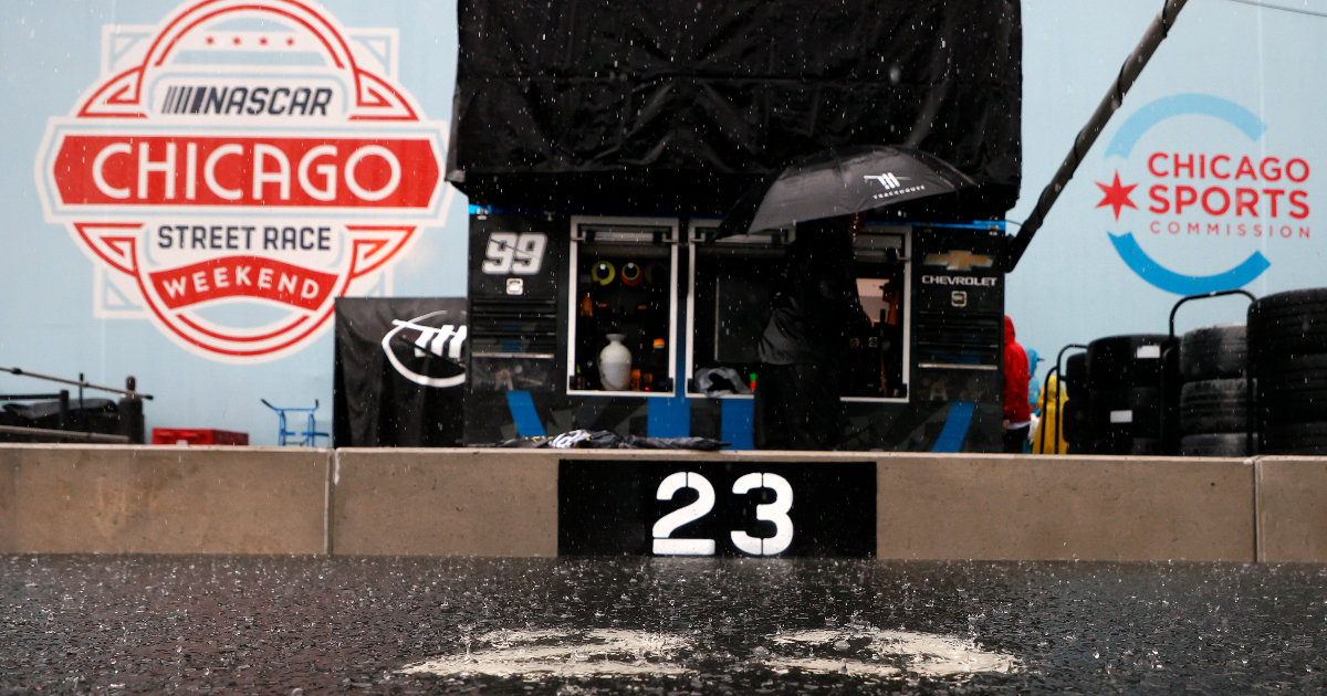 NASCAR crews show how deep standing water is, hold toy boat race on pit road in Chicago