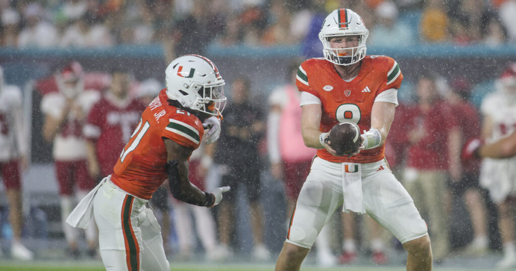 Miami Hurricanes quarterback Tyler Van Dyke hands out the football to running back Henry Parrish Jr.