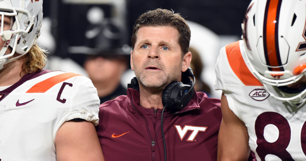 Oct 27, 2022; Raleigh, North Carolina, USA;Virginia Tech Hokies head coach Brent Pry (center) prepares to for the first half against the North Carolina State Wolfpack at Carter-Finley Stadium.