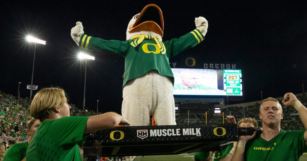 The Oregon Duck raises his fists in the air after doing 55 pushups