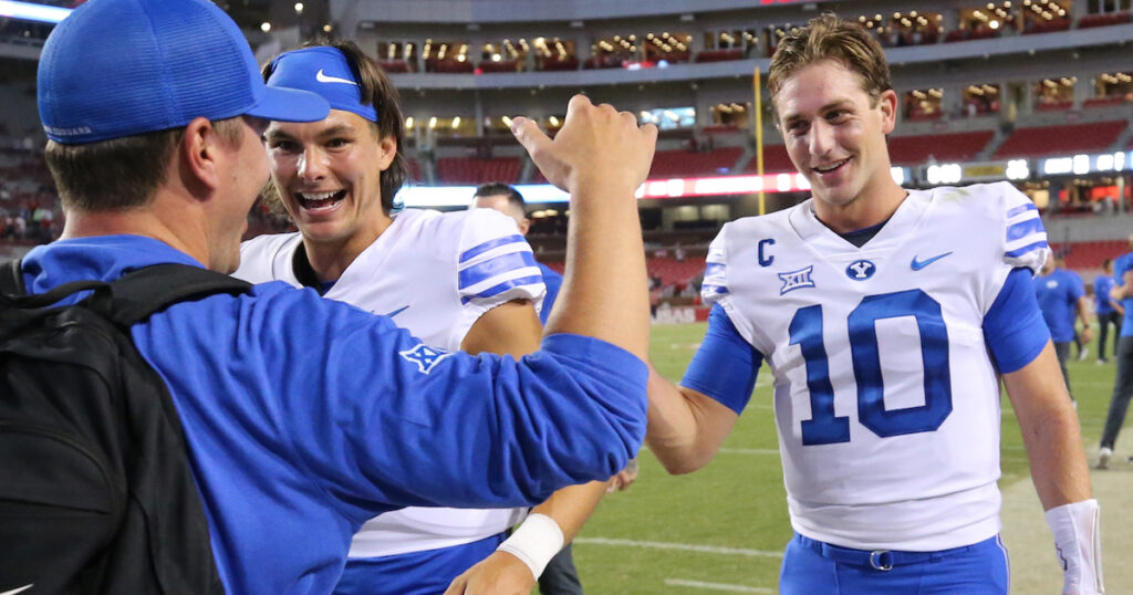 BYU Cougars quarterback Kedon Slovis  celebrates with a teammate and team personnel