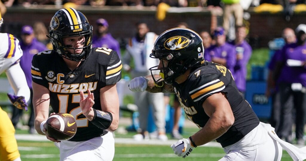 Missouri QB Brady cook hands it off to Cody Schrader