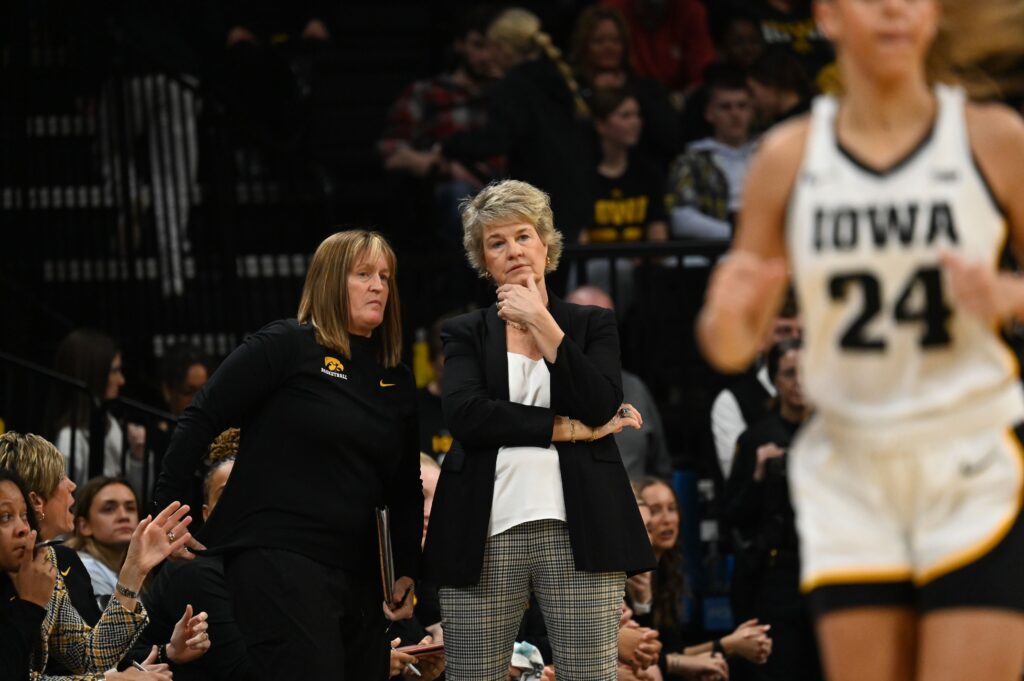 Iowa head coach Lisa Bluder talks with assistant Jenni Fitzgerald