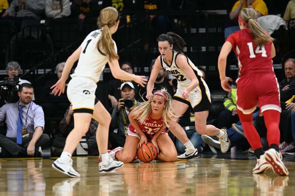 Caitlin Clark and Syndey Parrish battle for a loose ball.