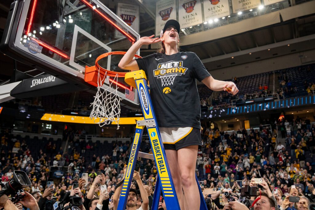 Iowa Hawkeyes guard Caitlin Clark (22) cuts down the net after beating LSU in the Elite 8 round of the NCAA Women's Basketball Tournament - © Zach Boyden-Holmes/The Register / USA TODAY NETWORK