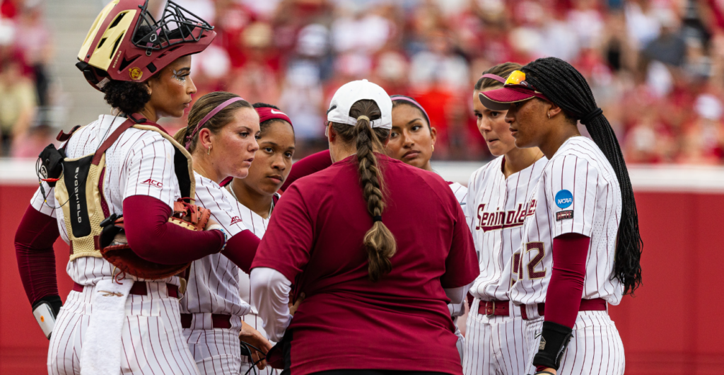 FSU softball coach Lonni Alameda speaks to her infielders during Thursday's loss at Oklahoma. (Courtesy of Florida State Sports Information)