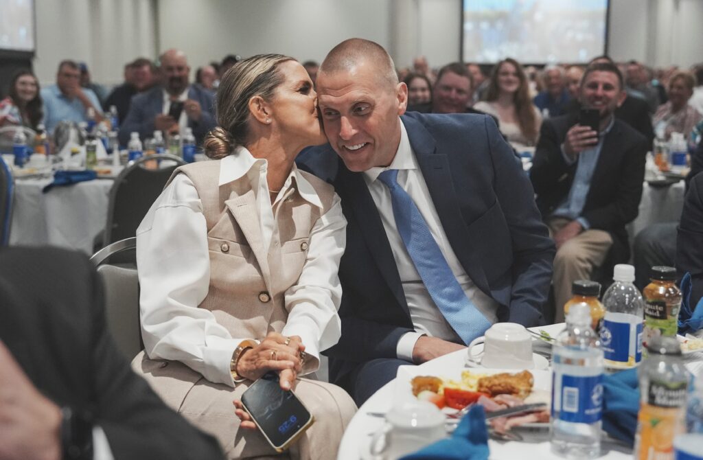 Mark Pope, head coach of the Kentucky men's basketball team, gets a kiss from his wife, Lee Anne, during bidding at the Kentucky State Fair's 60th annual ham auction on Thursday morning, Aug. 22, 2024 - © Matt Stone/The Louisville Courier Journal / USA TODAY NETWORK