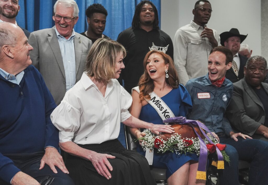 As Miss Kentucky's Chapel Tinius laughs, Kelly Craft grates the Grand Champion ham that she and her husband Joe Craft (far left) purchased for a record $10.5 million at the Kentucky State Fair's 60th annual ham auction on Thursday morning, Aug. 22, 2024 - © Matt Stone/The Louisville Courier Journal / USA TODAY NETWORK