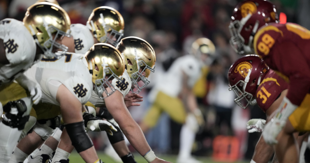 A general overall view of helmets at the line of scrimmage as Notre Dame Fighting Irish offensive lineman Zeke Correll (52) snaps the ball against the Southern California Trojans in the second half at United Airlines Field at Los Angeles Memorial Coliseum