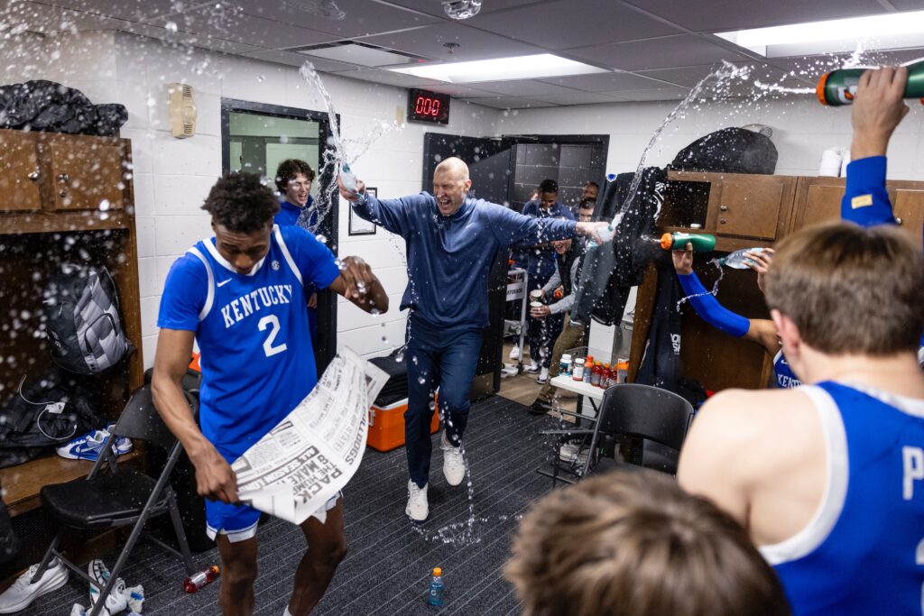 Kentucky players and Mark Pope spray water on Jaxson Robinson after the win at Mississippi State - Chet White, UK Athletics