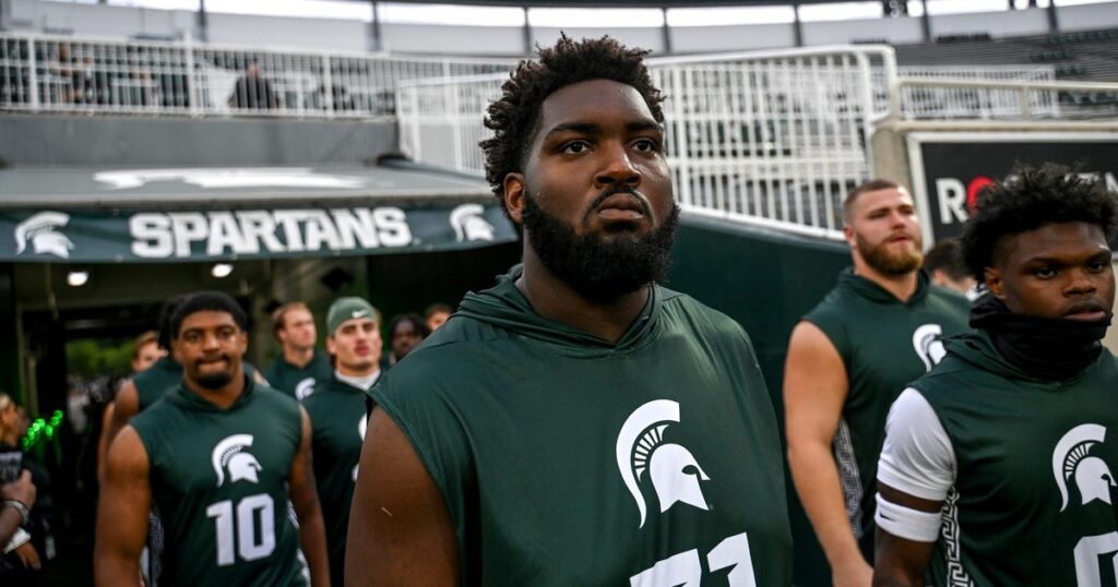 Michigan State's Kristian Phillips and the Spartans take the field for warm ups before the game against Florida Atlantic on Friday, Aug. 30, 2024, at Spartan Stadium in East Lansing. (© Nick King/Lansing State Journal / USA TODAY NETWORK)