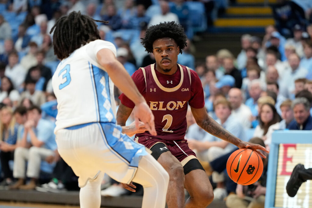 Nov 4, 2024; Chapel Hill, North Carolina, USA;  Elon Phoenix guard TJ Simpkins (2) with the ball as North Carolina Tar Heels guard Elliot Cadeau (3) defends in the first half at Dean E. Smith Center. Mandatory Credit: Bob Donnan-Imagn Images
