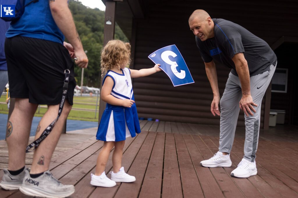 Mark Pope with a young Kentucky basketball fan, via Chet White, UK Athletics