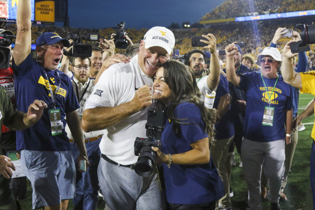 West Virginia head coach Rich Rodriguez celebates the win over Pitt with daughter Raquel