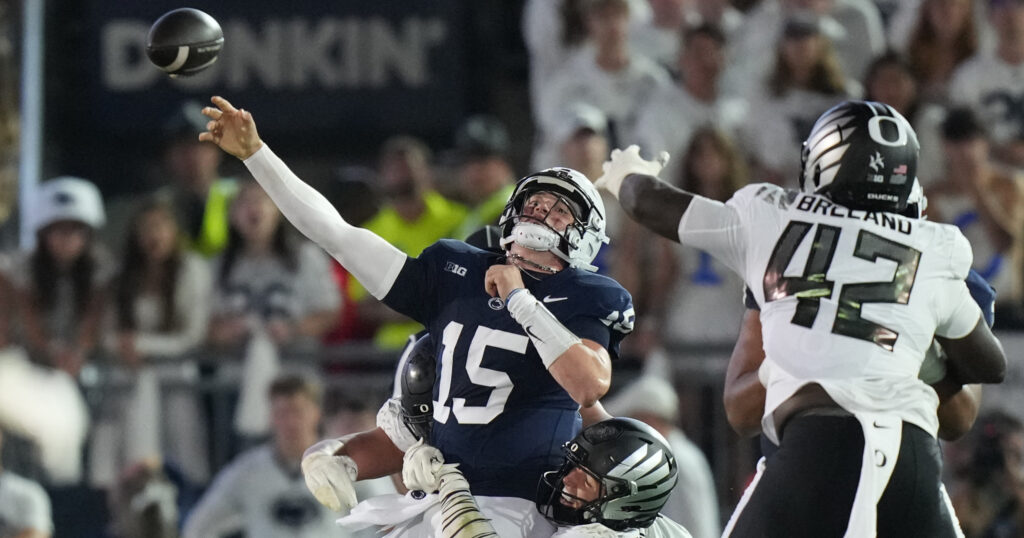 Sep 27, 2025; University Park, Pennsylvania, USA; Penn State Nittany Lions quarterback Drew Allar (15) is tackled by Oregon Ducks linebacker Kamar Mothudi (33) and linebacker Teitum Tuioti (44) during the second quarter at Beaver Stadium. Mandatory Credit: James Lang-Imagn Images