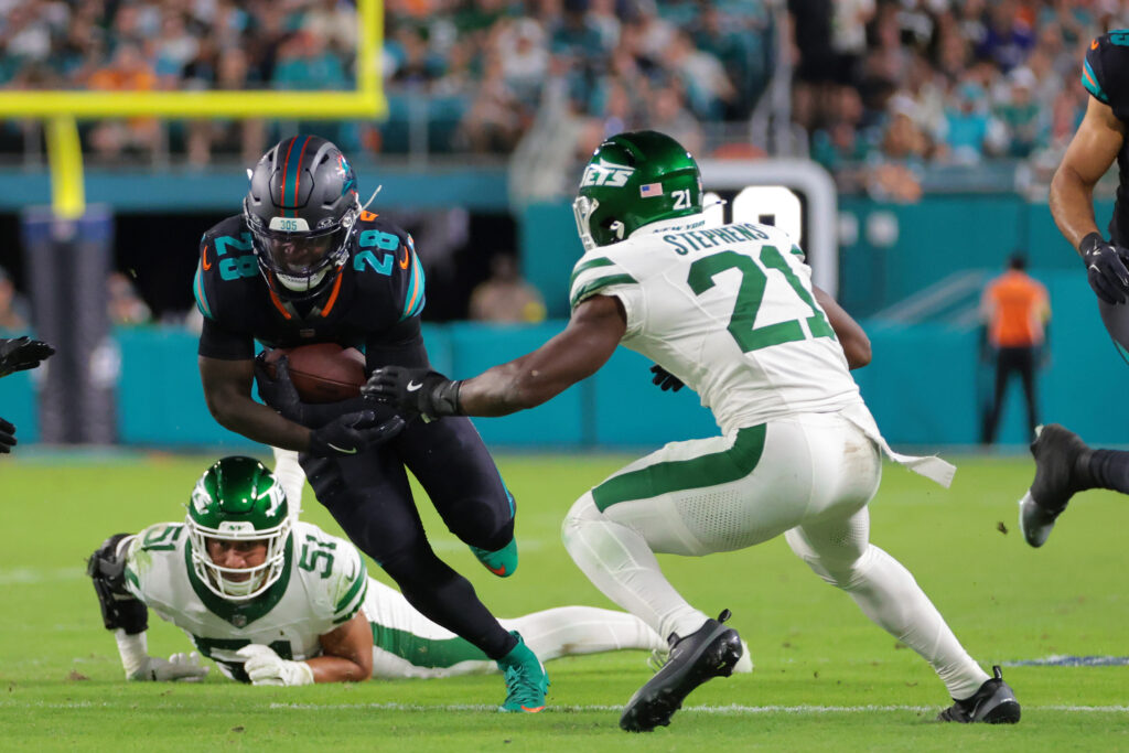 Sep 29, 2025; Miami Gardens, Florida, USA; Miami Dolphins running back De'von Achane (28) rushes the ball against New York Jets cornerback Brandon Stephens (21) during the second half at Hard Rock Stadium. Mandatory Credit: Sam Navarro-Imagn Images