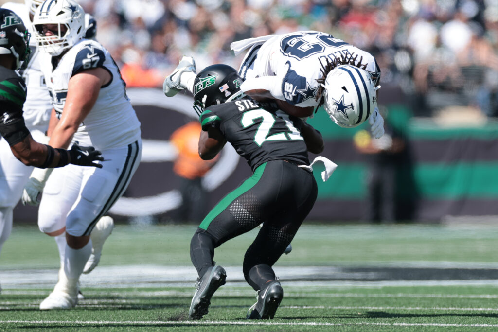 Oct 5, 2025; East Rutherford, New Jersey, USA; Dallas Cowboys running back Jaydon Blue (23) is tackled by New York Jets cornerback Brandon Stephens (21) during the first half at MetLife Stadium. Mandatory Credit: Vincent Carchietta-Imagn Images