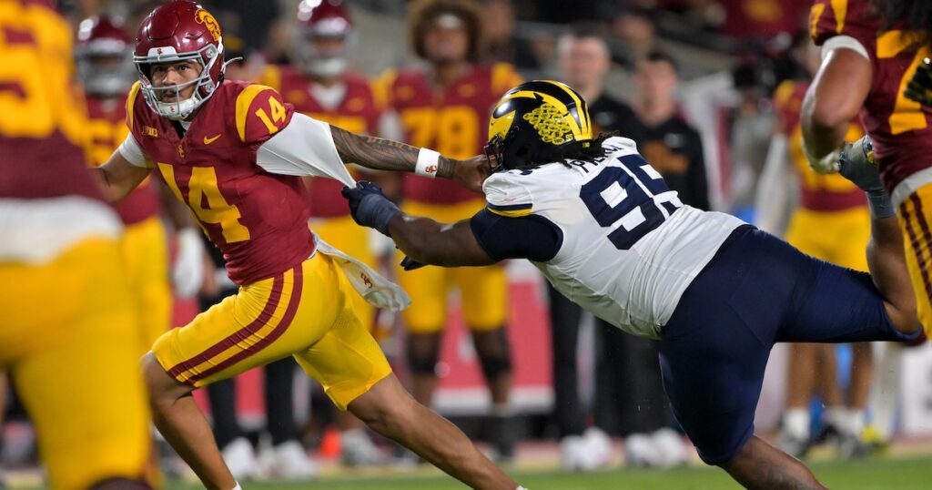 Oct 11, 2025; Los Angeles, California, USA; USC Trojans quarterback Jayden Maiava (14) is pressured by Michigan Wolverines defensive end Cameron Brandt (9) in the second half at United Airlines Field at the Los Angeles Memorial Coliseum. Mandatory Credit: Jayne Kamin-Oncea-Imagn Images