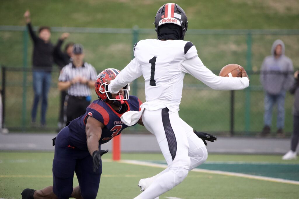 Aliquippa quarterback Marques Council Jr. stiff arms Kemon Spell in the Quips' 21-12 WPIAL Class-4A Championship win over McKeesport -- Andre Swinton // PSN